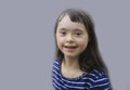 Cute down syndrome girl on the grey background.