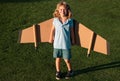 Cute dreamer boy playing with a cardboard airplane. Childhood. Fantasy, imagination. Royalty Free Stock Photo