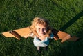 Cute dreamer boy playing with a cardboard airplane. Childhood. Fantasy, imagination. Royalty Free Stock Photo