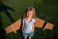 Cute dreamer boy playing with a cardboard airplane. Childhood. Fantasy, kids imagination. Royalty Free Stock Photo