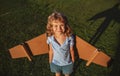 Cute dreamer boy playing with a cardboard airplane. Childhood. Fantasy, kids imagination. Royalty Free Stock Photo