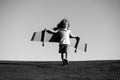 Cute dreamer boy playing with a cardboard airplane on sky. Childhood. Fantasy, imagination. Royalty Free Stock Photo