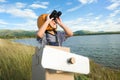 Cute dreamer little girl playing with cardboard planes and binoculars in a lakeside meadow on a sunny day. Childhood dream Royalty Free Stock Photo