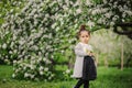 Cute dreamy toddler child girl walking in blooming spring garden