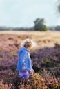 Cute Dutch girl in the scenic field with common heather