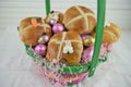 Cute Easter basket filled with fresh hot cross buns and easter eggs Royalty Free Stock Photo
