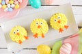 Cute Easter chick cupcakes, top view table scene with a white wood background Royalty Free Stock Photo