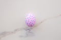 Cute Easter egg decorated by hand on a white table. Easter holiday concept. Beautiful egg speckled pink and blue Royalty Free Stock Photo