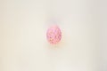 Cute Easter egg decorated by hand on a white table. Easter holiday concept. Beautiful egg speckled pink and blue Royalty Free Stock Photo