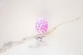 Cute Easter egg decorated by hand on a white table. Easter holiday concept. Beautiful egg speckled pink and blue Royalty Free Stock Photo
