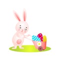 Cute easter rabbit on green grass full wheelbarrow