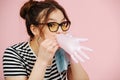 Playful young woman blowing air in a medical rubber glove