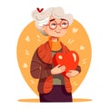 Cute elderly woman holding a red heart