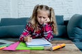 Cute elementary student feeling sad and confusing while doing difficult assignment with her laptop at home in primary school Royalty Free Stock Photo