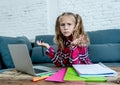 Cute elementary student feeling sad and confusing while doing difficult assignment with her laptop at home in primary school Royalty Free Stock Photo