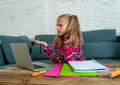 Cute elementary student feeling sad and confusing while doing difficult assignment with her laptop at home in primary school Royalty Free Stock Photo