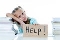 Cute elementary student feeling sad and confusing with too many schoolbooks at home in primary school Royalty Free Stock Photo