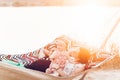 Cute, emotional baby girl in pretty dress with her mother and father in a hammock on vacation, funny baby face at sunset lake Royalty Free Stock Photo