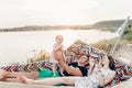 Cute, emotional baby girl in pretty dress with her mother and father in a hammock on vacation, funny baby face at sunset lake Royalty Free Stock Photo