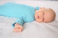 Cute emotional funny newborn infant boy in jumpsuit laying on bed. Infant baby facial expressions. Royalty Free Stock Photo