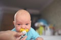 Cute emotional funny newborn infant boy in jumpsuit with pacifier dummy. Baby facial expressions Royalty Free Stock Photo