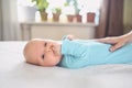 Cute emotional funny newborn infant crying boy laying on bed. Infant baby facial expressions. Royalty Free Stock Photo