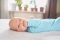 Cute emotional funny newborn infant crying boy laying on bed. Infant baby facial expressions. Royalty Free Stock Photo