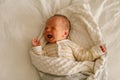 Cute emotional newborn little baby boy cry in crib. Royalty Free Stock Photo