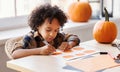 Cute ethnic child boy making Halloween home decorations