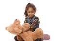 Cute ethnic girl playing with plush bear smiling