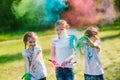 Cute european child girls celebrate Indian holi festival with colorful paint powder on faces and body.