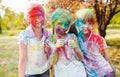 Cute european child girls celebrate Indian holi festival with colorful paint powder on faces and body