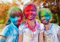 Cute european child girls celebrate Indian holi festival with colorful paint powder on faces and body