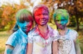 Cute european child girls celebrate Indian holi festival with colorful paint powder on faces and body