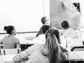 cute student girl solves task near blackboard in classroom mathematics Royalty Free Stock Photo