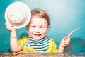 Cute excited funny baby with plate and spoon, babies eating. Kid boy eating healthy food. Royalty Free Stock Photo