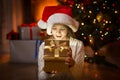 Cute excited girl looking in magic Christmas box at night Royalty Free Stock Photo