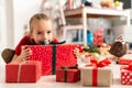 Cute excited young girl sitting on the living room floor surrounded by christmas presents, ready to open them. Royalty Free Stock Photo