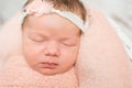 Cute face of sleepy newborn baby with hair band