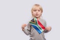 Cute fair-haired boy holding flag of South Africa. Education in South Africa