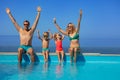 Cute family with happy kids sit on edge of a pool, lift hands Royalty Free Stock Photo