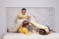 Cute family, parents with adorable child son playing with pillows Royalty Free Stock Photo