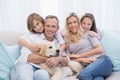 Cute family relaxing together on the couch with their dog Royalty Free Stock Photo