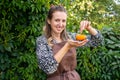 A cute farmer girl holds a small pumpkin in her hands