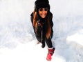 Cute fashionable young woman wearing winter outfit surrounded by snow