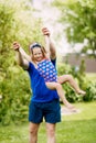 A cute father and a little girl are playing together. The child takes off in the hands of his father