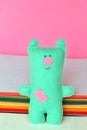 Cute felt bear. Funny bear toy in background of the colored felt sheets. Sewing crafts