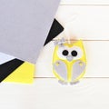 Cute felt owl toy. Grey, yellow, black, white felt. White background. Top view Royalty Free Stock Photo