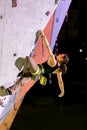 Cute female Athlete hanging on climbing Wall