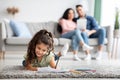 Cute Female Child Resting On Floor At Home And Drawing With Pencils Royalty Free Stock Photo